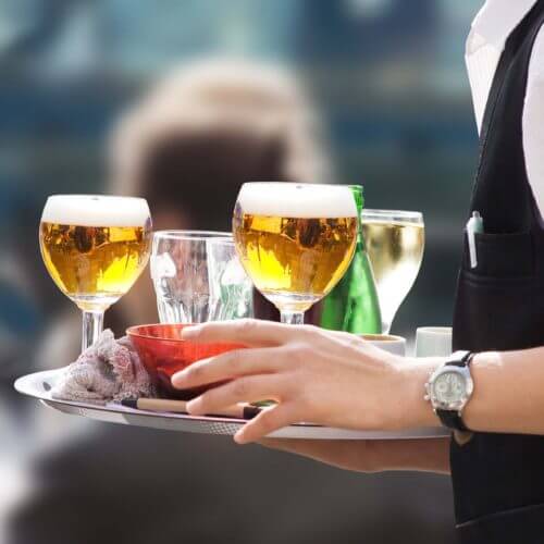 restaurant waiter carrying tray of drinks