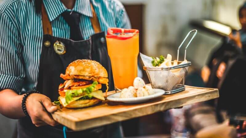 restaurant server carrying tray with food