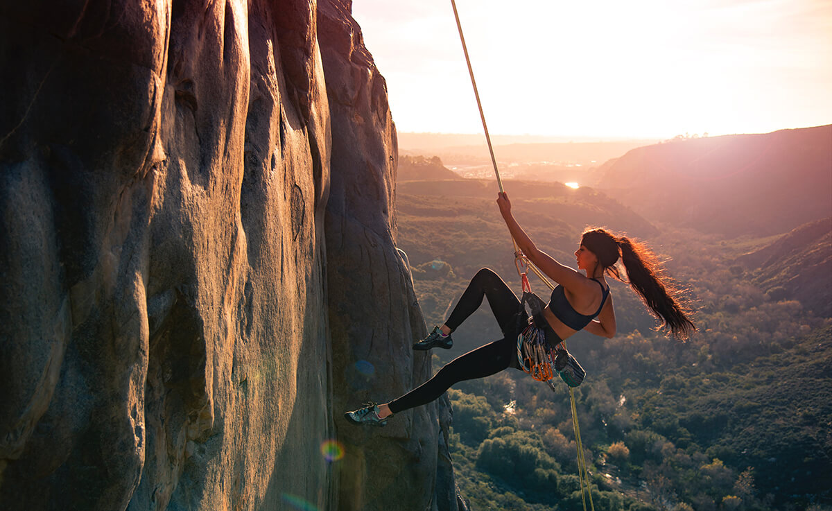 Woman climbing mountain rocks