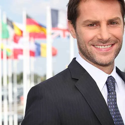 smiling man in front of international flags