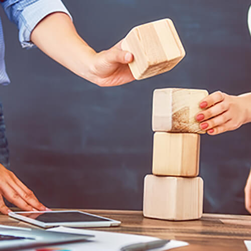 Two business people with wooden building blocks