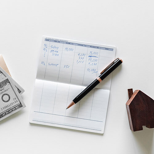 checkbook ledger, pen wooden house and money