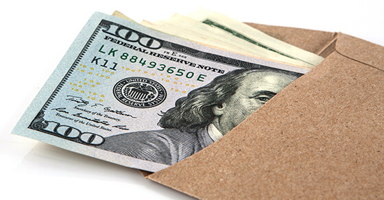 Hand holding envelope of cash