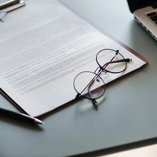 document with pen and eyeglasses